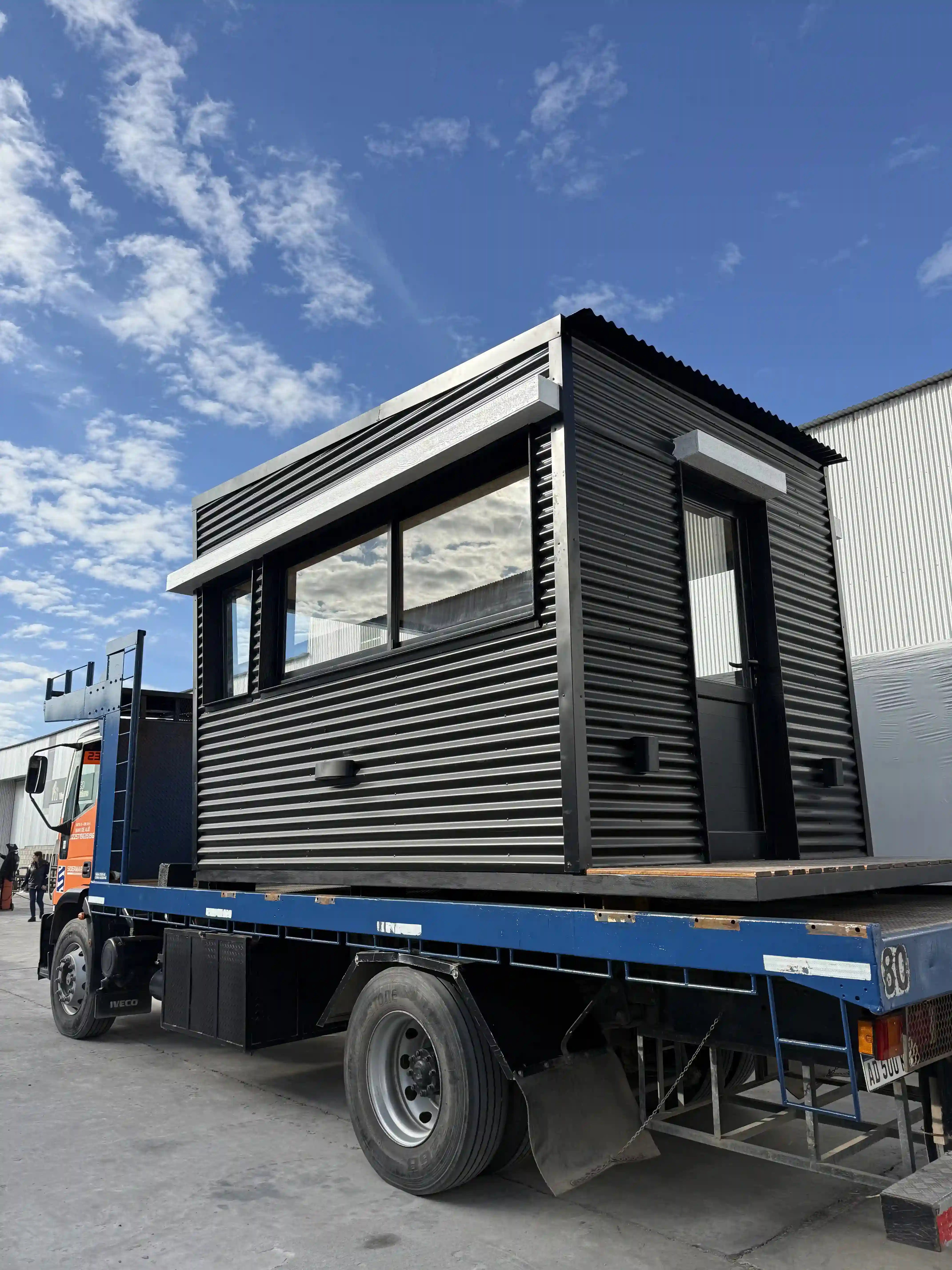 Casa modular negra en transporte especial hacia obra Faci House