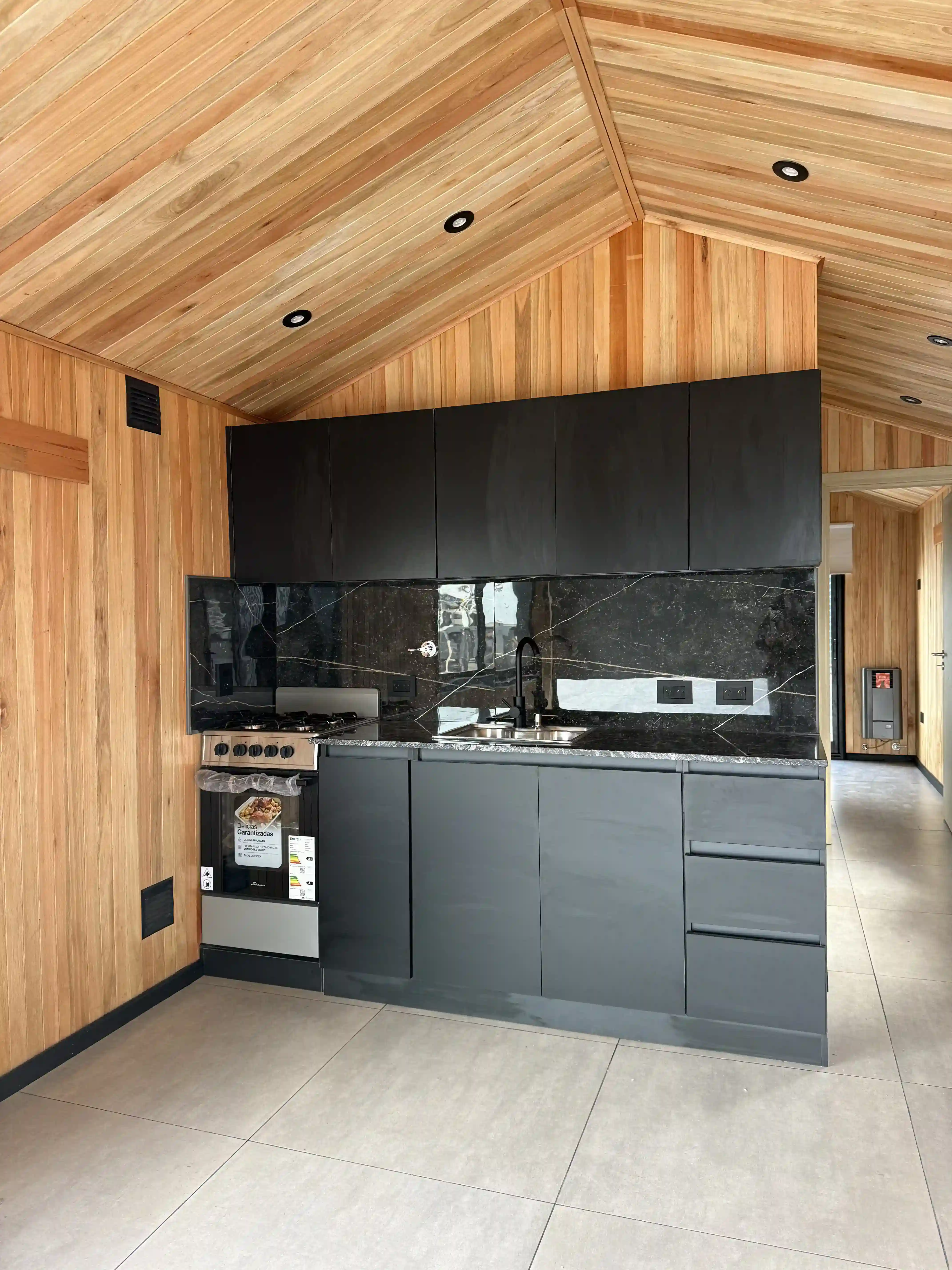 Cocina equipada con muebles negros y madera natural casa modular Faci House