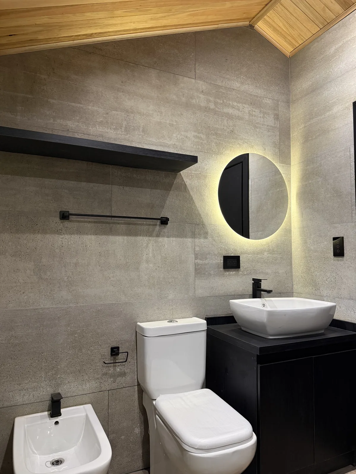 Baño con espejo circular retroiluminado y bacha de apoyo casa modular Faci House