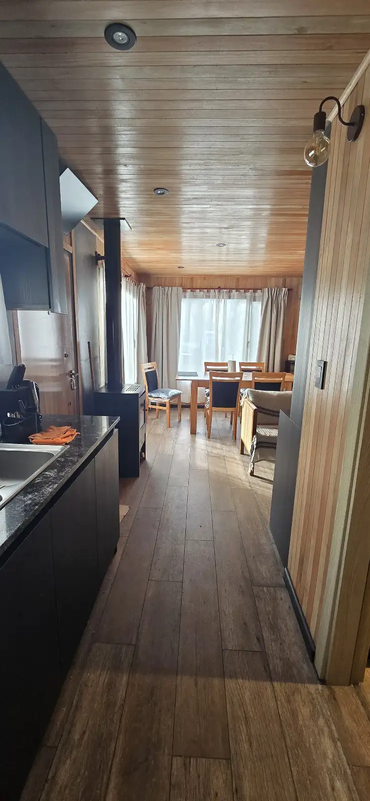 Cocina con estufa a leña y vista al comedor casa modular Faci House