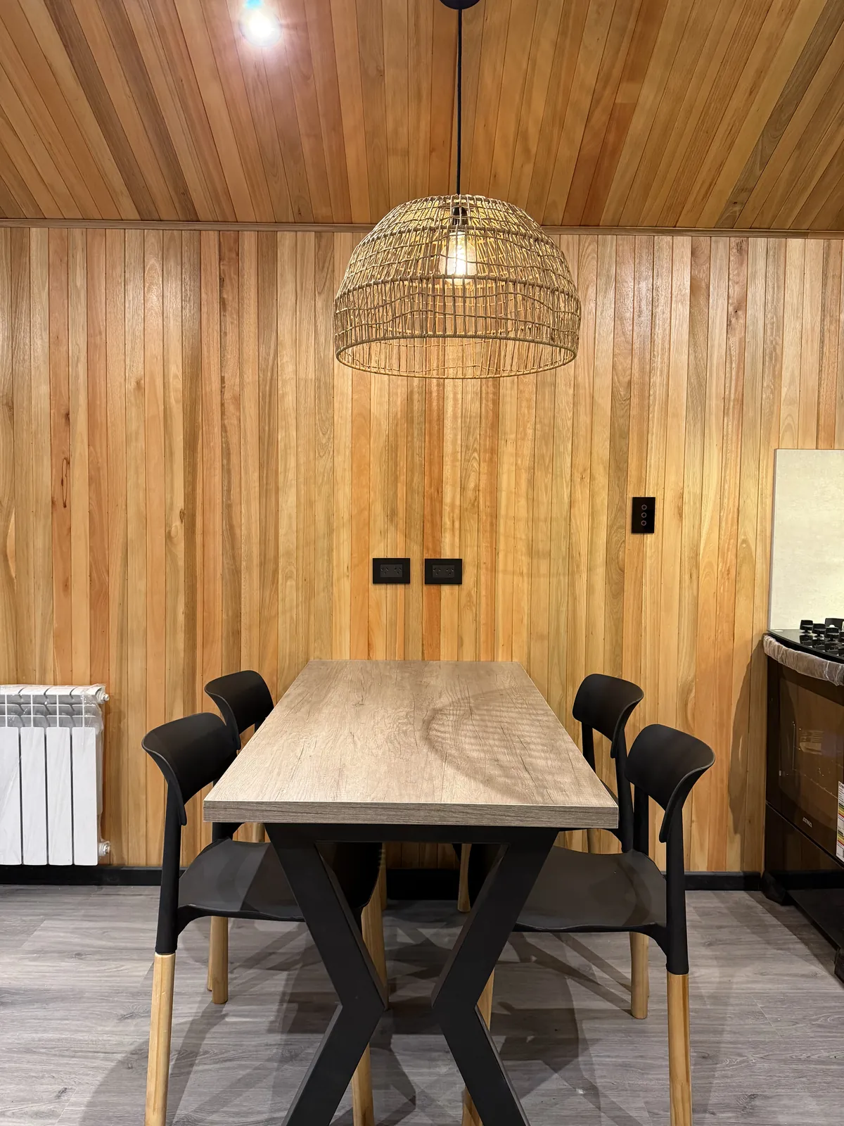 Mesa de comedor para cuatro personas con lámpara colgante de ratán casa modular Faci House