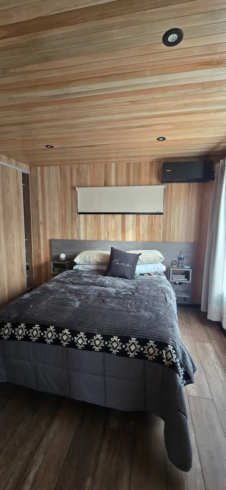 Dormitorio en suite con revestimiento de madera casa modular Faci House