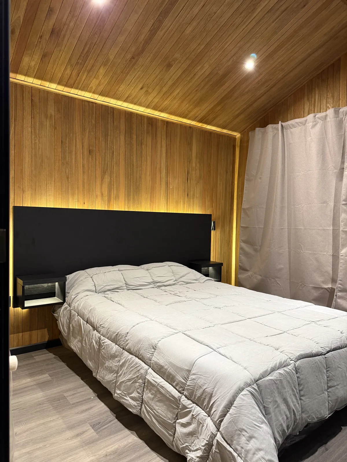 Dormitorio matrimonial con mesas de luz flotantes y techo de madera casa modular Faci House