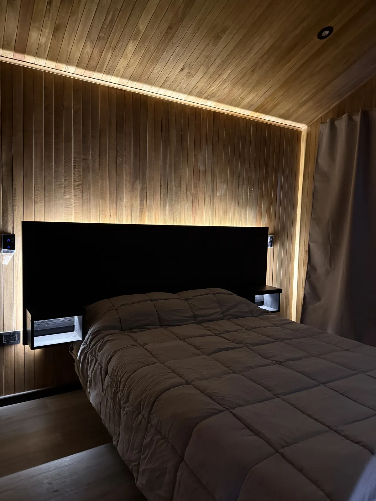 Dormitorio con respaldo negro e iluminación LED perimetral casa modular Faci House