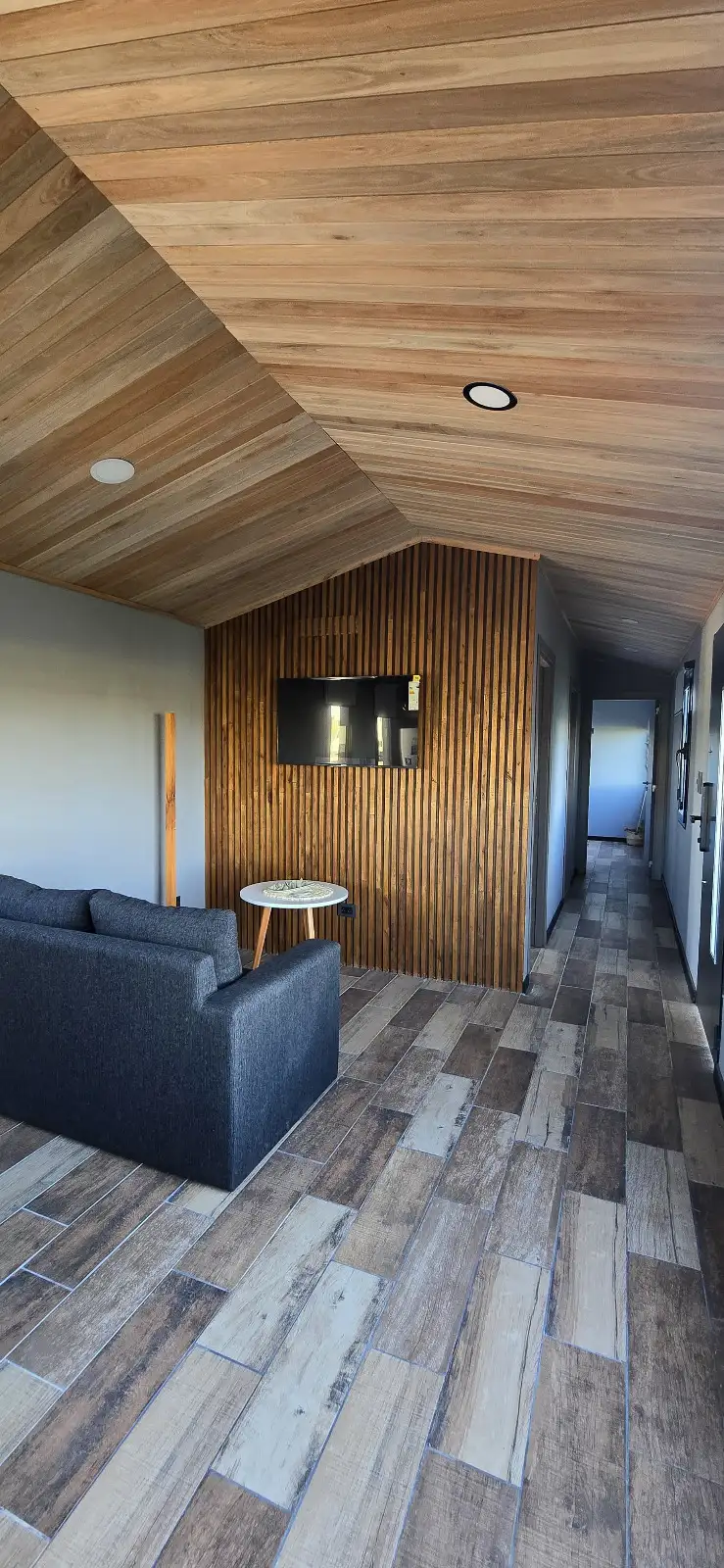 Living con estufa a leña y revestimiento de madera casa modular Faci House